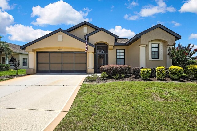 10155 Duffy Cir, Weeki Wachee, FL 34613 - view of front of house featuring stucco siding, an attached garage, a front yard, and driveway
