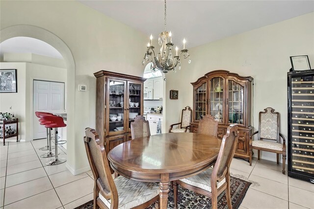 10155 Duffy Cir, Weeki Wachee, FL 34613 - dining area featuring light tile patterned floors, a chandelier, arched walkways, and wine cooler