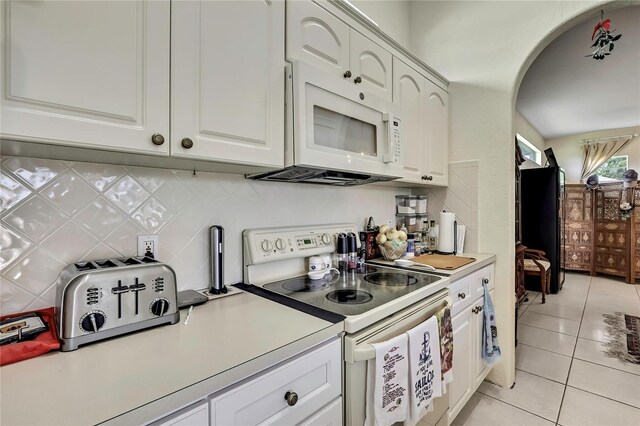 10155 Duffy Cir, Weeki Wachee, FL 34613 - kitchen with white appliances, light tile patterned floors, light countertops, and decorative backsplash