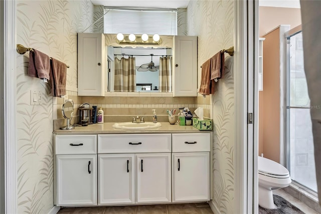 10155 Duffy Cir, Weeki Wachee, FL 34613 - bathroom featuring wallpapered walls, a shower stall, vanity, toilet, and baseboards