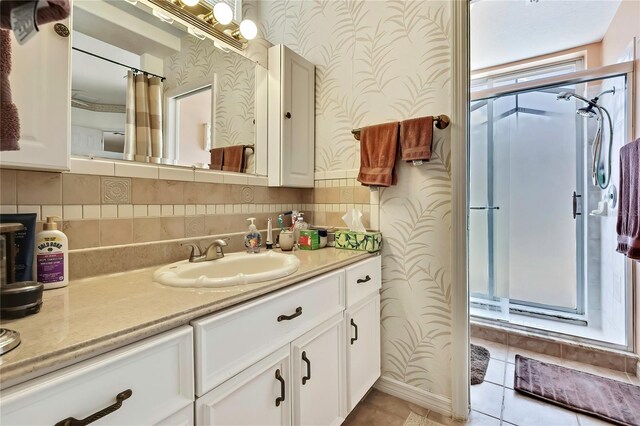 10155 Duffy Cir, Weeki Wachee, FL 34613 - full bath with wallpapered walls, a shower stall, vanity, tile patterned floors, and decorative backsplash