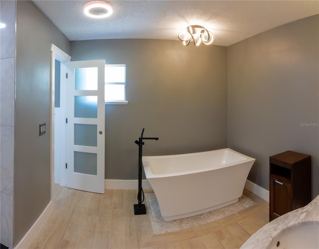 6172 Raleigh St, Spring Hill, FL 34606 - bathroom featuring a freestanding bath, a textured ceiling, baseboards, and vanity