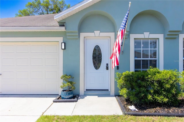 6172 Raleigh St, Spring Hill, FL 34606 - doorway to property featuring a garage, stucco siding, concrete driveway, and roof with shingles
