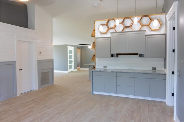 6172 Raleigh St, Spring Hill, FL 34606 - kitchen with decorative light fixtures, light wood-type flooring, light stone countertops, and baseboards
