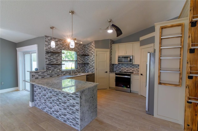 6172 Raleigh St, Spring Hill, FL 34606 - kitchen featuring stainless steel appliances, a peninsula, a sink, decorative backsplash, and vaulted ceiling