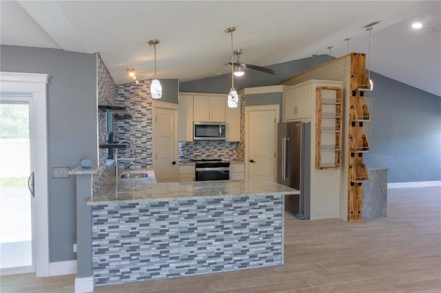 6172 Raleigh St, Spring Hill, FL 34606 - kitchen featuring appliances with stainless steel finishes, lofted ceiling, a sink, a peninsula, and backsplash