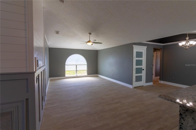 6172 Raleigh St, Spring Hill, FL 34606 - unfurnished living room featuring ceiling fan, a chandelier, a textured ceiling, baseboards, and light wood finished floors