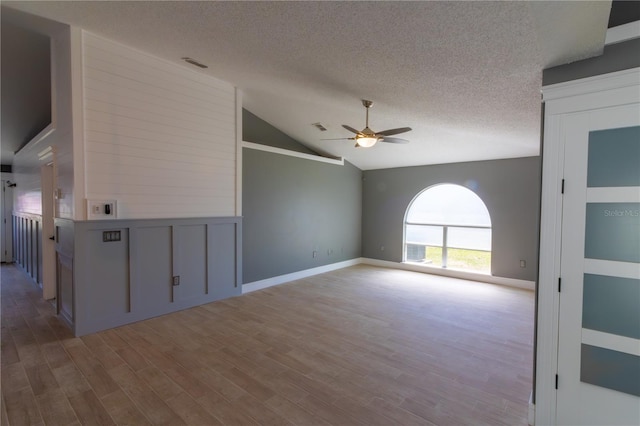 6172 Raleigh St, Spring Hill, FL 34606 - spare room featuring ceiling fan, vaulted ceiling, wood finished floors, a textured ceiling, and baseboards