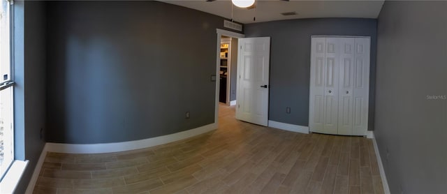 6172 Raleigh St, Spring Hill, FL 34606 - unfurnished bedroom with wood finished floors, baseboards, a closet, and multiple windows