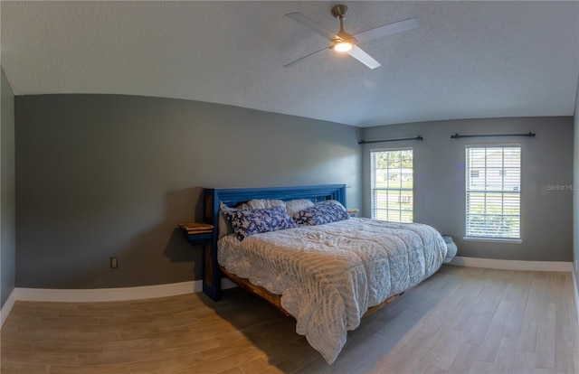 6172 Raleigh St, Spring Hill, FL 34606 - bedroom featuring vaulted ceiling, light wood-type flooring, baseboards, a textured ceiling, and a ceiling fan