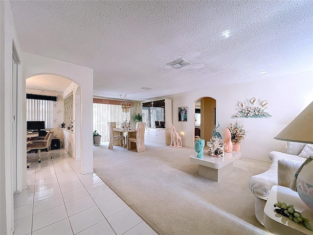 10111 Glen Moor Ln, Port Richey, FL 34668 - living room with arched walkways, light tile patterned floors, light carpet, and a textured ceiling