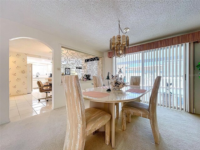 10111 Glen Moor Ln, Port Richey, FL 34668 - carpeted dining room featuring arched walkways, healthy amount of natural light, a chandelier, a textured ceiling, and tile patterned floors
