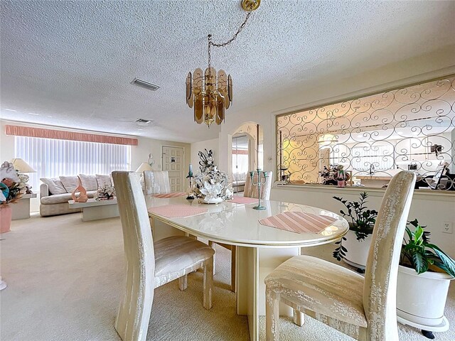 10111 Glen Moor Ln, Port Richey, FL 34668 - dining space with healthy amount of natural light, carpet, a chandelier, and a textured ceiling