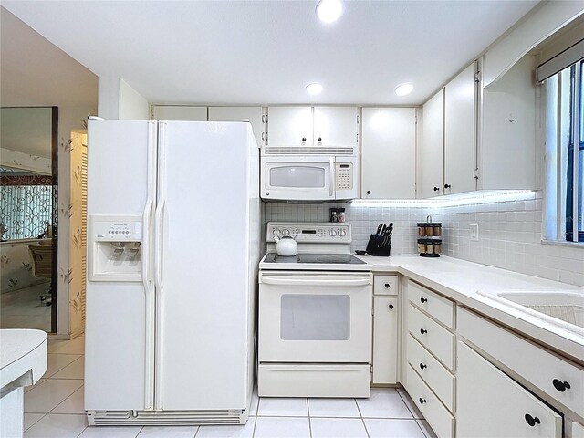 10111 Glen Moor Ln, Port Richey, FL 34668 - kitchen featuring white appliances, light tile patterned floors, light countertops, white cabinetry, and backsplash