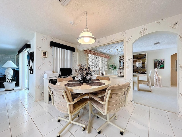 10111 Glen Moor Ln, Port Richey, FL 34668 - dining space with a textured ceiling, arched walkways, and light tile patterned flooring