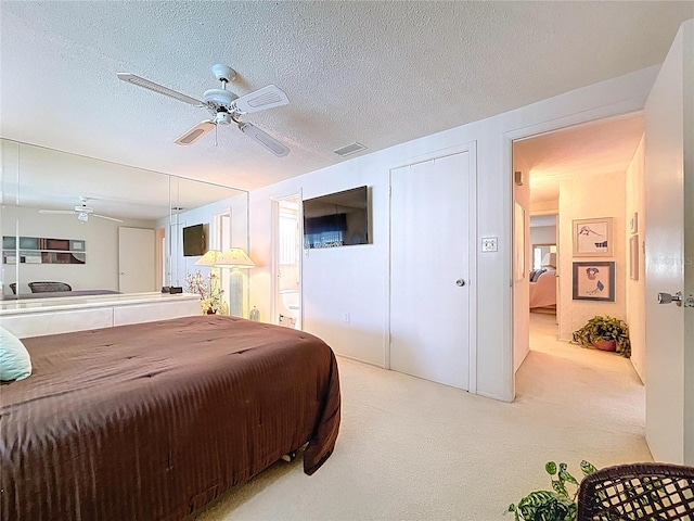 10111 Glen Moor Ln, Port Richey, FL 34668 - bedroom with light colored carpet, ceiling fan, connected bathroom, and a textured ceiling