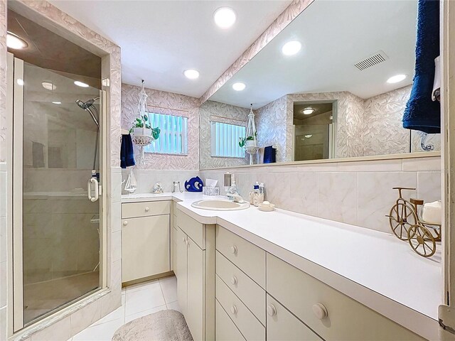 10111 Glen Moor Ln, Port Richey, FL 34668 - full bathroom with a shower stall, vanity, tile patterned flooring, tile walls, and wallpapered walls