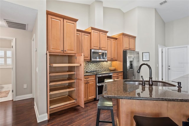 4923 Fort Peck Rd, New Port Richey, FL 34655 - kitchen with stainless steel appliances, a breakfast bar area, dark wood finished floors, decorative backsplash, and high vaulted ceiling