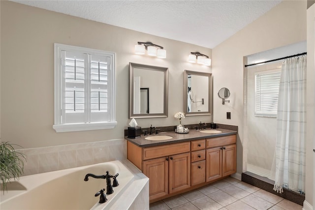 4923 Fort Peck Rd, New Port Richey, FL 34655 - full bathroom featuring a garden tub, plenty of natural light, double vanity, tile patterned floors, and a textured ceiling