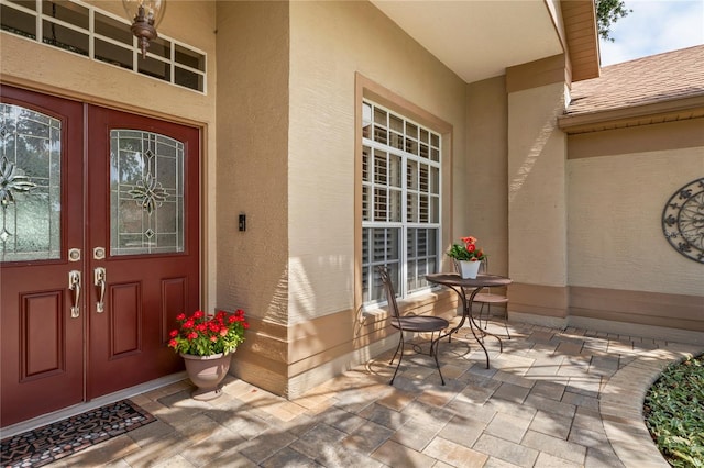 4923 Fort Peck Rd, New Port Richey, FL 34655 - view of exterior entry with french doors, stucco siding, and a shingled roof