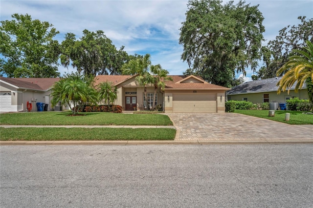 4923 Fort Peck Rd, New Port Richey, FL 34655 - single story home featuring decorative driveway, a garage, a front lawn, and stucco siding