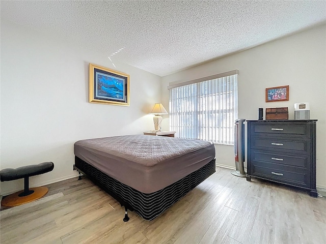 2139 Sea Pines Ct, Spring Hill, FL 34606 - bedroom with light wood-type flooring, a textured ceiling, and baseboards