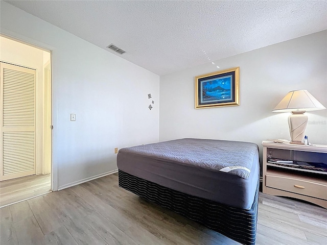 2139 Sea Pines Ct, Spring Hill, FL 34606 - bedroom featuring wood finished floors, a textured ceiling, and baseboards