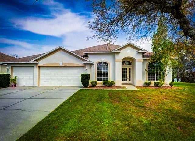 5701 Brackenwood Dr, Spring Hill, FL 34609 - view of front of property with a garage, stucco siding, driveway, and a front lawn