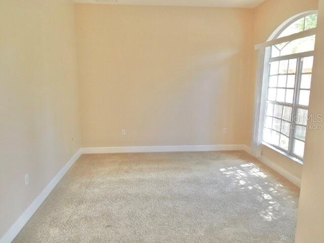 5701 Brackenwood Dr, Spring Hill, FL 34609 - carpeted empty room featuring baseboards