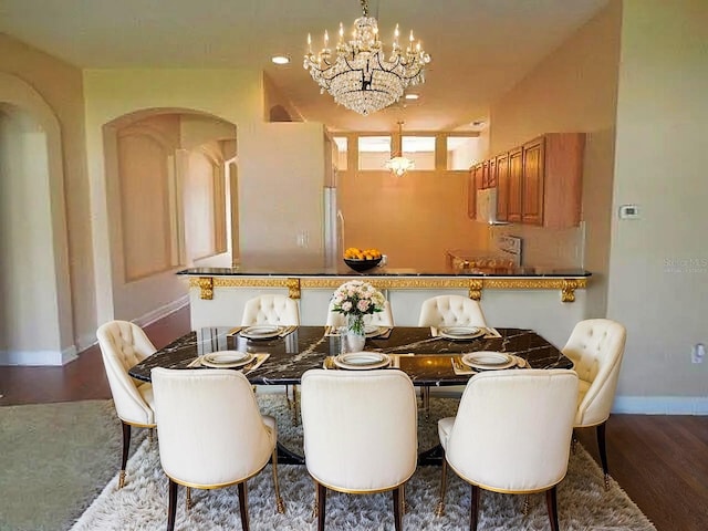 5701 Brackenwood Dr, Spring Hill, FL 34609 - dining area featuring wood finished floors, arched walkways, and a chandelier