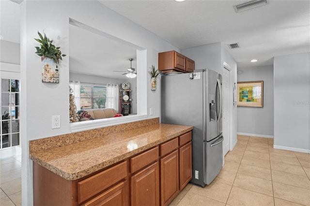 6315 Shane Ln, New Port Richey, FL 34653 - kitchen featuring stainless steel refrigerator with ice dispenser, light tile patterned floors, a ceiling fan, and brown cabinets