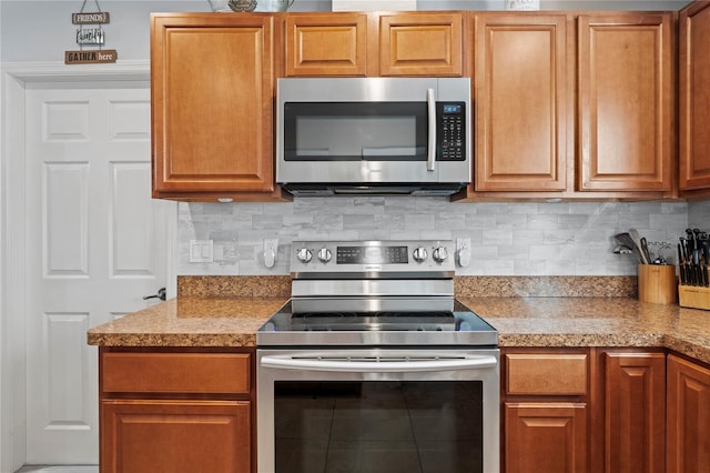 6315 Shane Ln, New Port Richey, FL 34653 - kitchen featuring appliances with stainless steel finishes, backsplash, and brown cabinets
