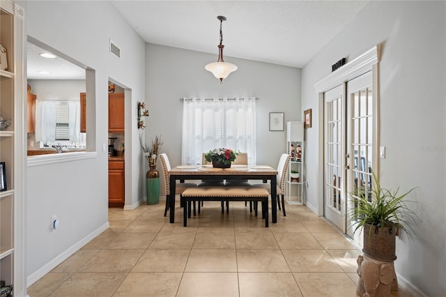 6315 Shane Ln, New Port Richey, FL 34653 - dining area featuring vaulted ceiling, french doors, baseboards, and light tile patterned floors