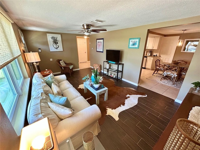 7861 Raintree Dr, New Port Richey, FL 34653 - living area featuring wood finished floors, a ceiling fan, a textured ceiling, and baseboards