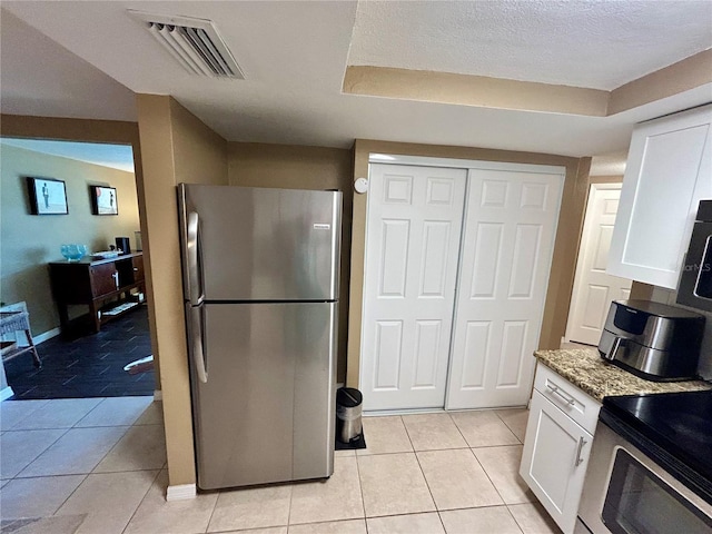 7861 Raintree Dr, New Port Richey, FL 34653 - kitchen with appliances with stainless steel finishes, white cabinetry, light stone countertops, and light tile patterned floors