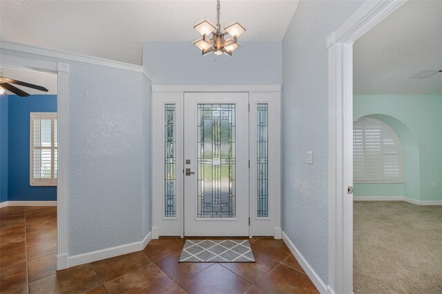 3609 Montclair Dr, New Port Richey, FL 34655 - entrance foyer featuring dark tile patterned flooring, a ceiling fan, a chandelier, a textured wall, and baseboards