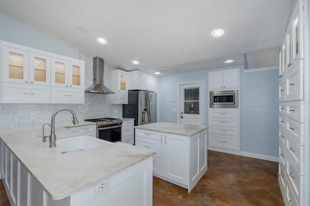 3609 Montclair Dr, New Port Richey, FL 34655 - kitchen with wall chimney exhaust hood, a sink, stainless steel appliances, backsplash, and a peninsula