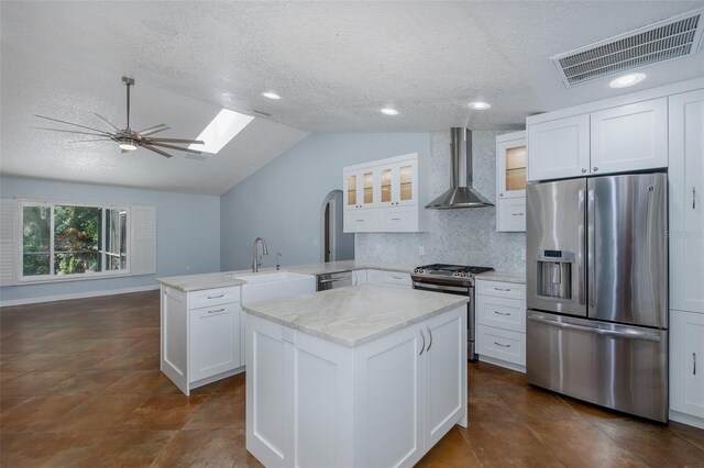 3609 Montclair Dr, New Port Richey, FL 34655 - kitchen featuring appliances with stainless steel finishes, wall chimney exhaust hood, a peninsula, a sink, and a textured ceiling