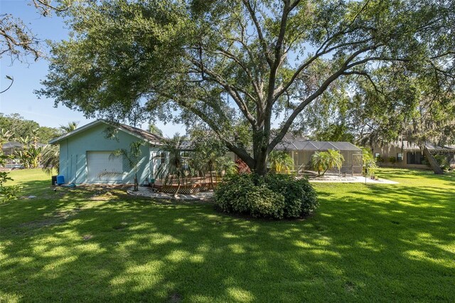 3609 Montclair Dr, New Port Richey, FL 34655 - view of green lawn with a garage and a lanai