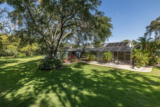 3609 Montclair Dr, New Port Richey, FL 34655 - view of grassy yard with glass enclosure and a patio