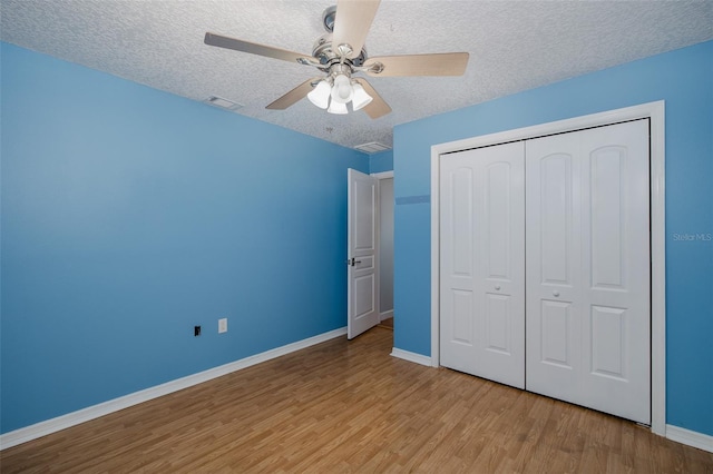 3609 Montclair Dr, New Port Richey, FL 34655 - unfurnished bedroom featuring a textured ceiling, wood finished floors, baseboards, a closet, and a ceiling fan