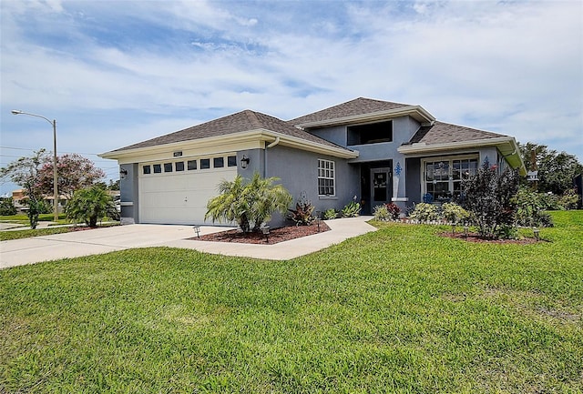 14011 Shoal Dr, Hudson, FL 34667 - prairie-style house with stucco siding, driveway, an attached garage, a front lawn, and a shingled roof