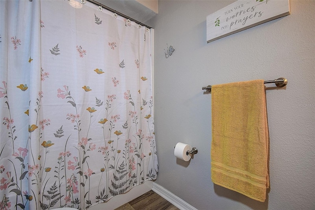 14011 Shoal Dr, Hudson, FL 34667 - full bathroom featuring wood finished floors, baseboards, and a shower with shower curtain