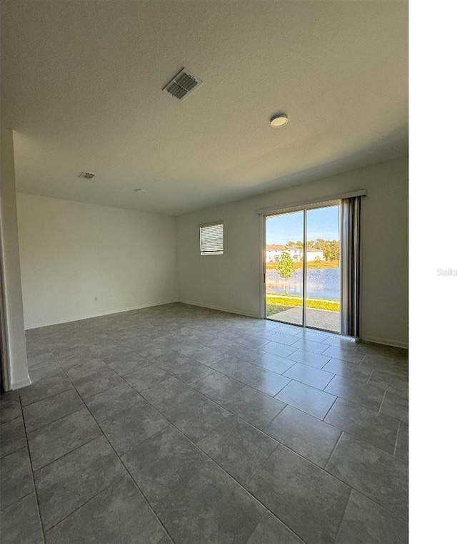 7433 Stone Creek Trl, Kissimmee, FL 34747 - unfurnished room with dark tile patterned flooring and baseboards
