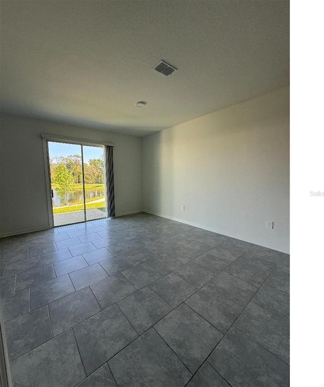 7433 Stone Creek Trl, Kissimmee, FL 34747 - spare room featuring dark tile patterned floors and baseboards