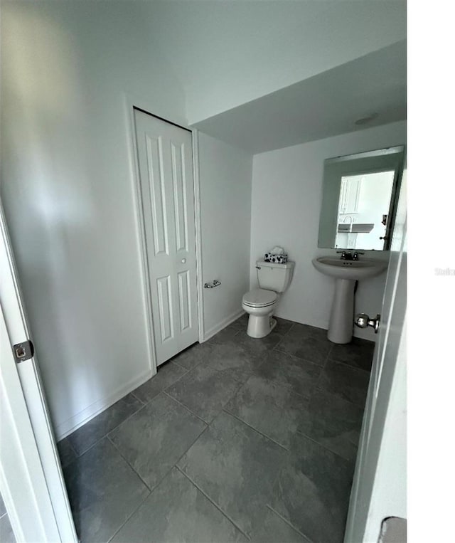 7433 Stone Creek Trl, Kissimmee, FL 34747 - half bathroom with toilet, a sink, and tile patterned flooring