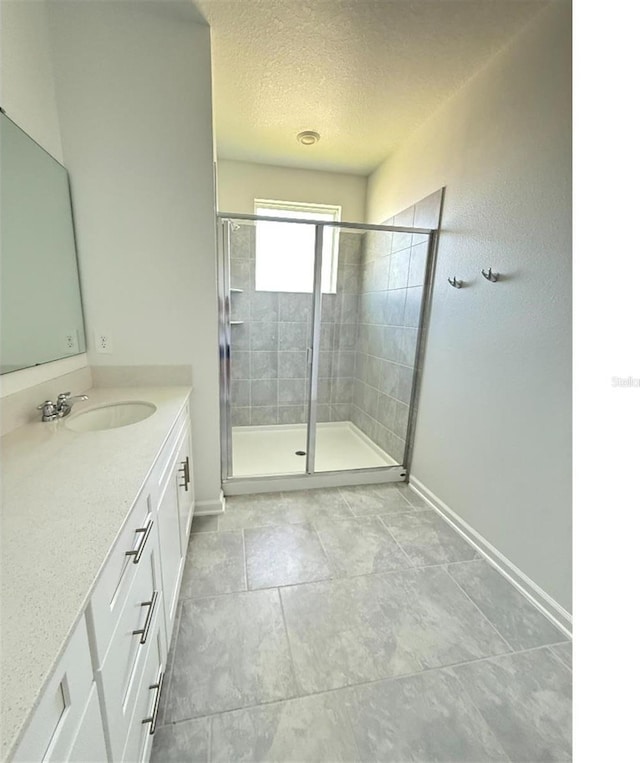 7433 Stone Creek Trl, Kissimmee, FL 34747 - bathroom featuring vanity, a stall shower, a textured ceiling, and baseboards