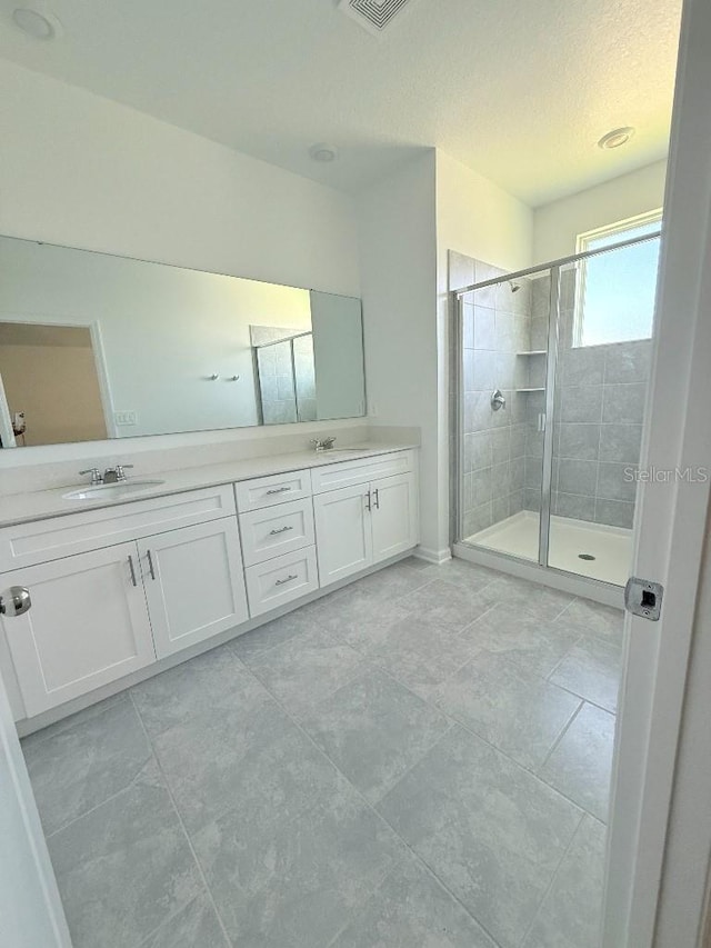 7433 Stone Creek Trl, Kissimmee, FL 34747 - bathroom featuring a stall shower, double vanity, and a textured ceiling