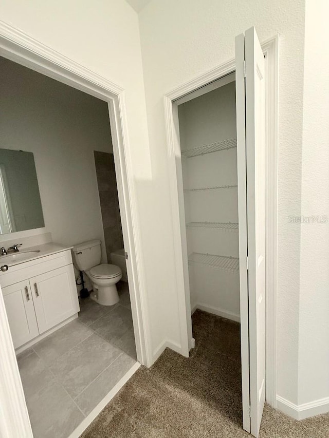 7433 Stone Creek Trl, Kissimmee, FL 34747 - bathroom with vanity, toilet, baseboards, and a spacious closet