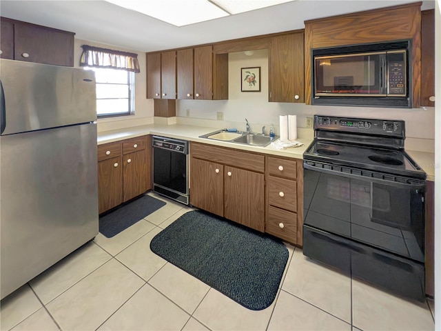 5627 Ferguson Ct Unit 1303, New Port Richey, FL 34652 - kitchen featuring black appliances, a sink, light countertops, light tile patterned flooring, and brown cabinets